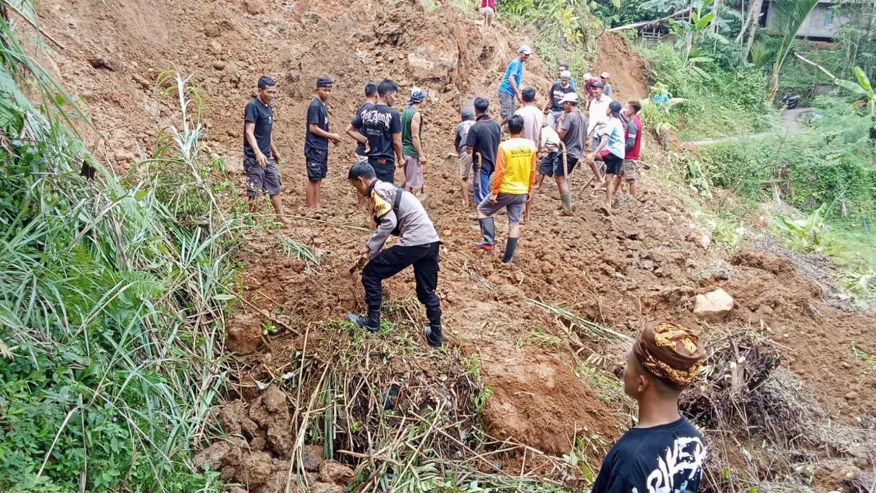 Puluhan warga bersama aparat desa, Babinsa, dan Bhabinkamtibmas langsung bergotong royong membersihkan material longsor yang menutup jalan, Rabu (1/10/2025).