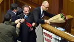 Seorang anggota parlemen bernama Oleg Barna tampak menyeret PM Arseny Yatsenyuk (kanan) dari podium saat membacakan laporan tahunan kinerja Pemerintah Ukraina di Majelis Tinggi Parlemen Ukraina, 11 Desember 2015. (Sergei SUPINSKY/AFP)