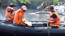 Personel gabungan menggunakan perahu karet saat membersihkan sampah di Kali Ciliwung. (Liputan6.com/Herman Zakharia)