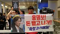 Seorang pria memegang spanduk bertuliskan "Hong Myung-bo! Ludahkan uangnya dan keluar! Bubarkan KFA" sambil menunggu kedatangan pelatih kepala Timnas Korea Selatan, Hong Myung-bo, yang telah mengumumkan pengunduran dirinya setelah timnya tersingkir di babak penyisihan grup Piala Dunia FIFA 2026, di Bandara Internasional Seoul-Incheon, Incheon pada 30 Juni 2026. Kekalahan telak Korea Selatan di babak pertama Piala Dunia telah memicu kemarahan di dalam negeri dan seruan untuk perombakan total di pucuk pimpinan belum mereda setelah pengunduran diri pelatih. Pelatih Korea Selatan mengundurkan diri pada 28 Juni 2026, sehari setelah timnya tersingkir dari babak penyisihan grup Piala Dunia dan setelah mendapat kecaman dari presiden negara tersebut.
(JADE GAO/AFP)