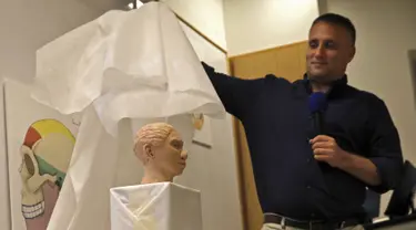 Liran Carmel dari Universitas Hebrew menunjukkan model cetak 3D wajah gadis spesies manusia prasejarah Denisovan setelah penelitian menggunakan data metilasi DNA selama konferensi pers di Universitas Ibrani di Yerusalem (19/9/2019). (AFP Photo/Menahem Kahana)