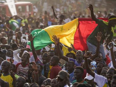 Penggemar klub sepak bola Senegal merayakan kemenangan tim mereka saat melawan Ekuador di laga grup A Piala Dunia 2022 di Qatar, pada layar video yang dipasang di zona penggemar, Dakar, Senegal, Selasa (29/11/2022). Skuad Lions of Teranga berhasil meraih kemenangan dengan skor 2-1 dalam pertandingan yang digelar di Stadion Internasional Khalifa. (AP Photo/Leo Correa)