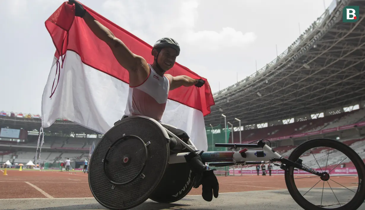 Pebalap kursi roda Indonesia, Jaenal Aripin, melakukan selebrasi usai meraih medali perak pada Asian Para Games cabang atletik nomor balap kursi roda 200 meter T 54 di SUGBK, Jakarta, Jumat (12/10). (Bola.com/Vitalis Yogi Trisna)