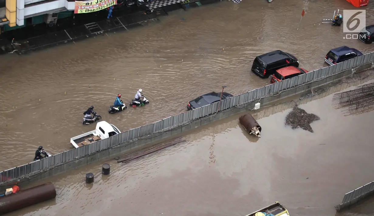 Pengendara sepeda motor mendorong kendaraannya akibat banjir di Jalan Boulevard Barat Raya, Kelapa Gading, Jakarta Utara, Kamis (15/2). Hujan lebat mengakibatkan kawasan tersebut kebanjiran. (Liputan6.com/Arya Manggala)