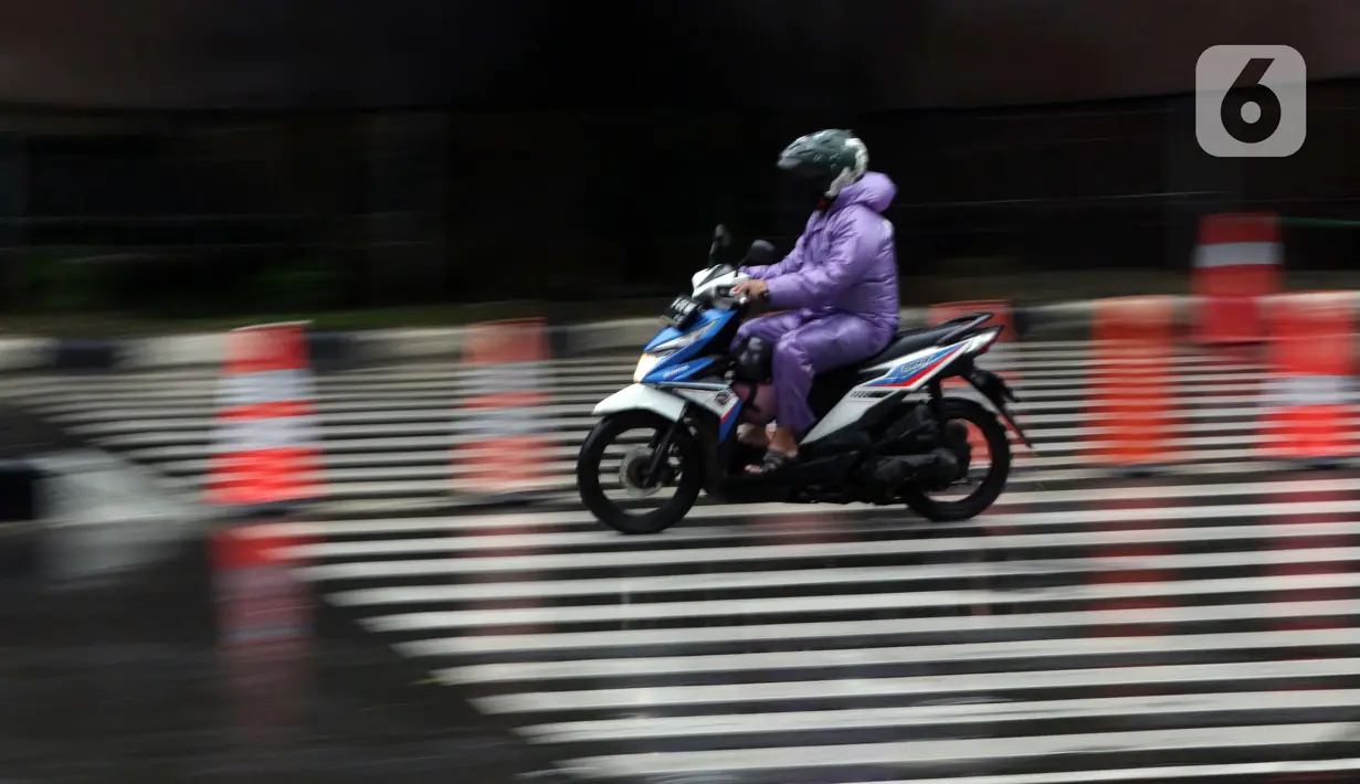 Pengendara mengenakan jas hujan saat melintas di kawasan Kuningan, Jakarta, Kamis (18/12/2021). BMKG memprakirakan potensi hujan lebat yang mungkin disertai petir dan angin kencang hingga 21 Februari di beberapa provinsi di Indonesia, termasuk DKI Jakarta. (Liputan6.com/Helmi Fithriansyah)