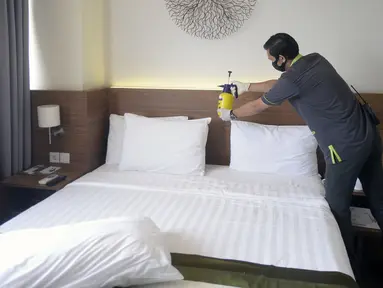 Pegawai melakukan penyemprotan disinfektan di kamar Hotel Grand Whiz Poins Simatupang, Jakarta, Kamis (16/4/2020). Hotel ini menyediakan paket isolasi mandiri untuk mendukung program pembatasan sosial berskala besar (PSBB) di tengah pandemi virus corona COVID-19. (merdeka.com/Dwi Narwoko)