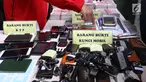 Petugas menunjukkan barang bukti saat rilis kasus pemalsuan dokumen dan uang palsu di Jakarta, Rabu (20/12). Bareskrim Polri menangkap sebanyak 13 tersangka yang mulai beroperasi sejak 2014 di wilayah Jakarta dan Jawa Barat. (Liputan6.com/Angga Yuniar)