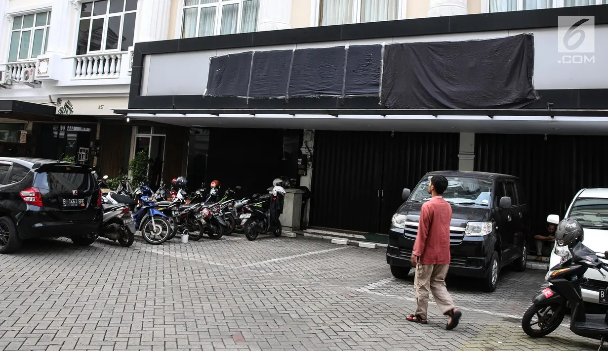 Seorang pria melintas di depan markas besar DPP HTI di Jakarta, Kamis (20/7). Kemenkum HAM secara resmi telah mencabut status badan hukum organisasi kemasyarakatan HTI.(Liputan6.com/Faizal Fanani) 