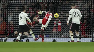 Penyerang Arsenal, Eddie Nketiah (tengah) saat mencetak gol ketiga timnya ke gawang Manchester United pada pertandingan lanjutan Liga Inggris di stadion Emirates di London, Minggu (22/1/2023). Arsenal menang tipis atas Manchester United dengan skor 3-2. (AP Photo/Ian Walton)