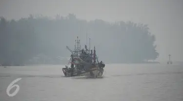 Nelayan berlayar dengan perahu di sungai Narathiwat yang diselimuti kabut asap, Thailand, Senin (5/10/2015). Kabut asap dari kebakaran hutan di Indonesia kini menyelimuti provinsi di wilayah selatan Thailand. (AFP PHOTO/Madaree TOHLALA)