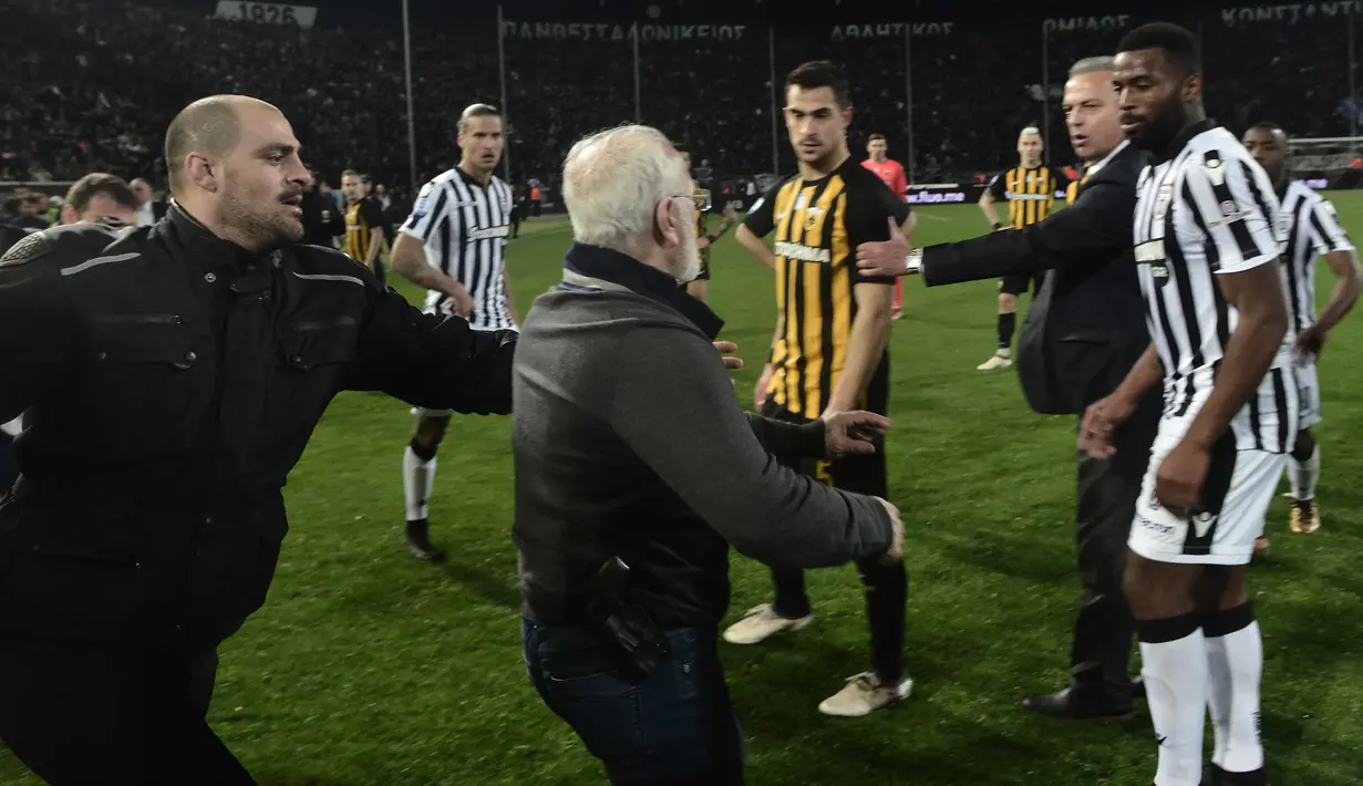 Presiden PAOK Ivan Savvidis turun ke lapangan dan mengancam wasit setelah gol klubnya dianulir pada Liga Yunani kontra AEK Athens di Stadion Toumbas, Minggu (11/3). Ivan Savvidis memasuki lapangan dengan membawa senjata di pinggangnya (AFP PHOTO/stringer)