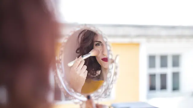 Seorang perempuan sedang bercermin sambil mengenakan makeup (Foto Dok: Freepik/freepik)