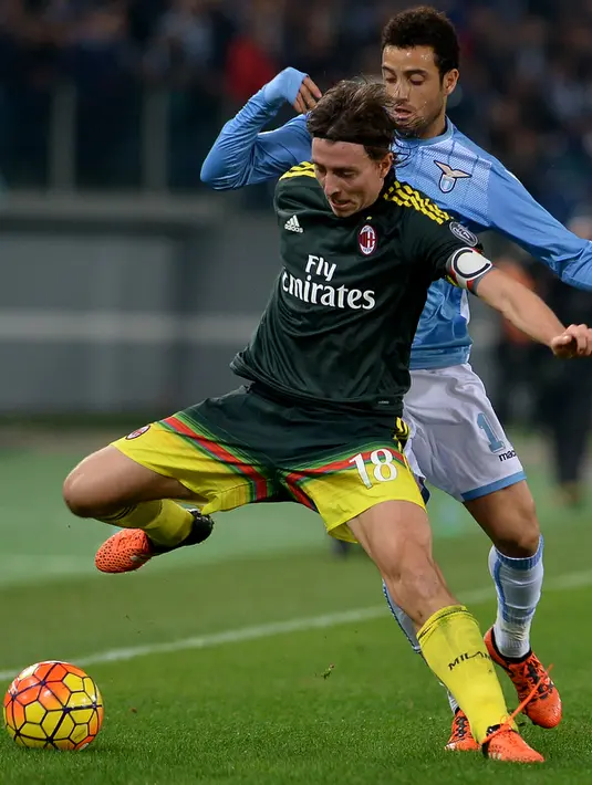 Gelandang AC Milan, Riccardo Montolivo (depan) berusaha mengontrol bola dari kejaran Laziao, Felipe Anderson pada lanjutan liga serie A di Olimpico Stadium, Italia (1/2/2015). AC Milan menang atas Lazio dengan skor 1-3. (AFP PHOTO/TIZIANA FABI)