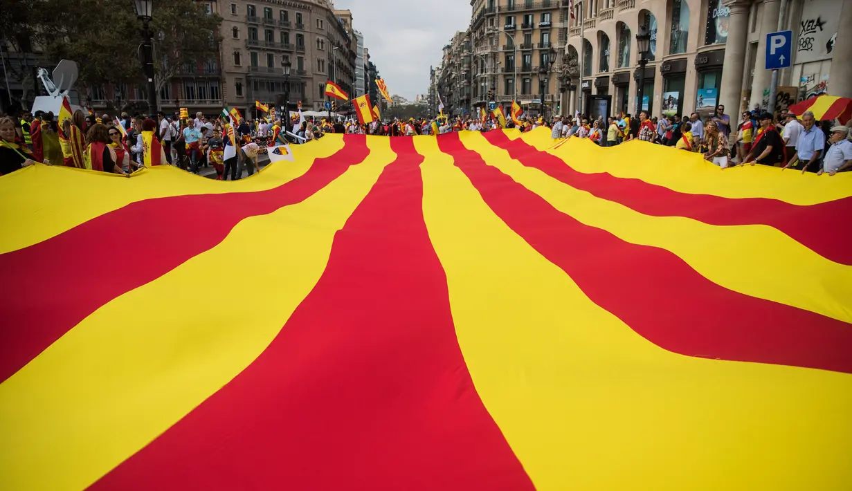 Sejumlah orang mengarak bendera Catalonia raksasa ketika merayakan Hari Nasional Spanyol di jalanan Barcelona, Kamis (12/10). Hari Nasional sendiri memperingati kedatangan pertama Christopher Columbus di Amerika pada tahun 1492. (AP / Santi Palacios)