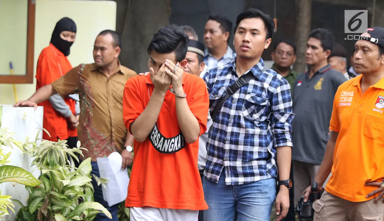 Tersangka pembunuhan wanita yang ditemukan tewas di dalam lemari digiring petugas jelang memeragakan adegan peristiwa di TKP di kawasan Mampang, Jakarta, Jumat (23/11). 13 adegan dilakukan para tersangka. (Liputan6.com/Helmi Fithriansyah)