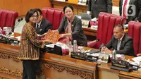 Menteri Keuangan (Menkeu) Sri Mulyani Indrawati menyerahkan draf pandangan pemerintah kepada Ketua DPR RI Puan Maharani saat rapat Paripurna DPR RI Ke-13 Masa Persidangan II Tahun Sidang 2022-2023 di Kompleks Parlemen, Senayan, Jakarta, Kamis (15/12/2022). DPR menyetujui Rancangan Undang-undang Pengembangan dan Penguatan Sektor Keuangan menjadi UU PPSK. (Liputan6.com/Angga Yuniar)