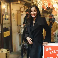 Ia memakai maxi coat, kemeja, short, dan boots tinggi sepaha, serta menjinjing tas berwarna hitam. (Foto: IG @kiranalarasati)