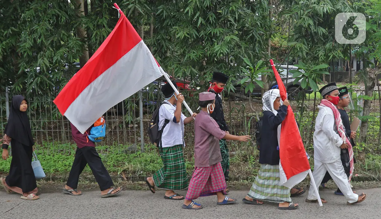 Sejumlah anak pengajian melakukan pawai di Jalan Raya Tapos, Depok, Jawa Barat, Kamis (22/10/2020). Pengajian Kampung Tapos menggelar pawai menyambut Hari Santri Nasional 2020 yang diperingati setiap tanggal 22 Oktober. (Liputan6.com/Herman Zakharia)