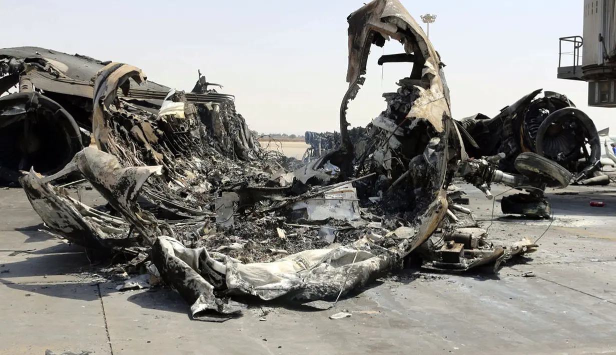 Beberapa pesawat dikabarkan terbakar dan rusak setelah terjadi pertempuran yang melibatkan kelompok-kelompok militan di Bandara Internasional Tripoli, Libya, (21/7/2014). (REUTERS/Hani Amara)