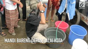 Kesulitan akses air bersih yang dirasakan warga Jakarta Utara membuat mereka berdemo di depan Balai Kota sambil mandi.