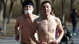 Peserta tak mengenakan baju saat  mengikuti lomba lari " Half- Naked Marathon" di Olympic Forest, Beijing, Cina, (28/2).  Lomba yang diselenggarakan tiap tahunnya ini sebagai bentuk gaya hidup ramah lingkungan. (REUTERS / Kim Kyung - Hoon)