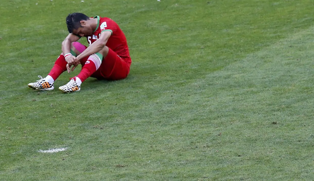 Pemain belakang Iran, Amir-Hossein Sadeghi, terduduk usai dikalahkan Agentina 0-1 di babak penyisihan Piala Dunia Grup F di Stadion Mineirao, Belo Horizonte, Brasil (21/6/2014). (REUTERS/Leonhard Foeger)