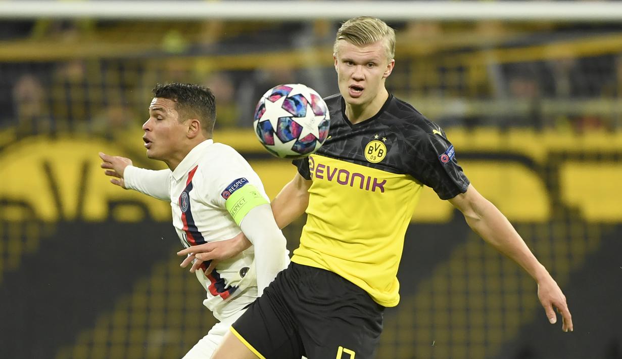 Striker Borussia Dortmund, Erling Braut Haaland, berebut bola dengan bek Paris Saint-Germain, Thiago Silva, pada leg pertama 16 besar Liga Champions di Signal Iduna Park, Dortmund, Rabu (19/2) dini hari WIB. Dortmund menang 2-1 atas PSG.(AFP/Ina Fassbender)