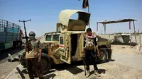 Dua anggota kelompok ISIS bergaya di depan Humvee milik pasukan keamanan Irak yang direbut di Kota Mosul. (forum.milua.org)