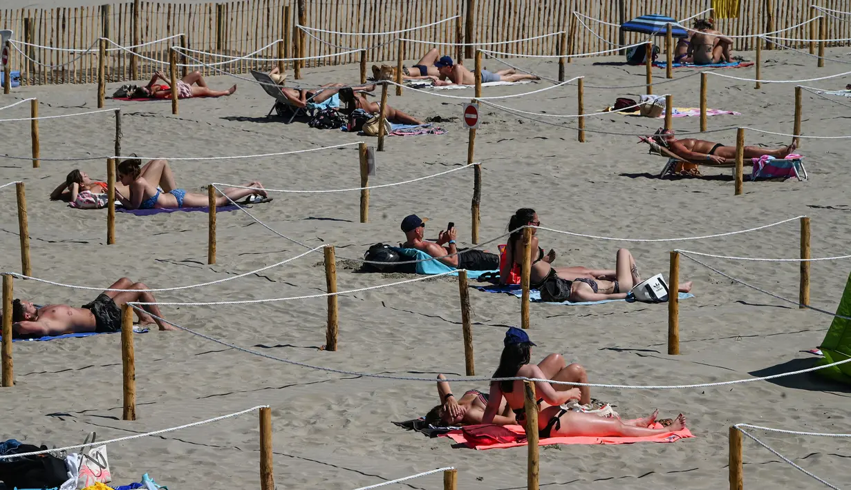Orang-orang berjemur di Sunset Beach dengan area terpisah untuk mematuhi jaga jarak di La Grande-Motte, Prancis, Selasa (26/5/2020). Cara ini dilakukan pemerintah Prancis yang mengaku mencontohnya dari otoritas di Spanyol yang telah terlebih dahulu memperkenalkannya (Pascal GUYOT/AFP)
