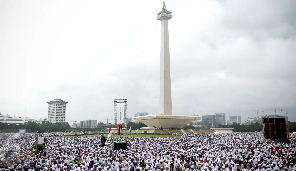 Massa aksi damai 2 Desember melaksanakan salat Jumat di Monas, Jakarta, Jumat (2/12). Meski hujan mengguyur, massa tetap bertahan di saf masing-masing dan melangsungkan salat Jumat bersama-sama. (Liputan6.com/Faizal Fanani)