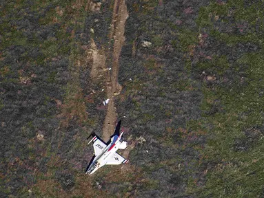 Pesawat  F-16 milik tim Thunderbirds Angkatan Udara AS jatuh di Colorado Springs setelah flyover di acara kelulusan Akademi Angkatan Udara, Kamis (2/6). Pilot Mayor Alex Turner yang mengemudikan pesawat selamat meski terluka. (Reuters/John Wark)