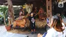 Seorang anak berfoto dengan diorama bernuansa Natal di lingkungan Gereja Katedral, Jakarta, Rabu (22/12/2021). Jemaat yang akan beribadah di Gereja Katedral Jakarta nantinya akan dibatasi untuk mencegah penularan COVID-19. (Liputan6.com/Angga Yuniar)