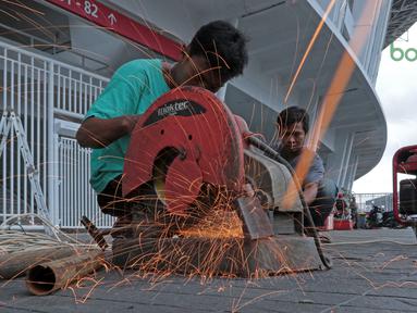 Pekerja memotong pipa untuk perbaikan pintu stadion yang rusak di Stadion Utama Gelora Bung Karno, Kamis (22/2/2018). Empat pintu stadion yang mengalami kerusakan adalah pintu bernomor 5B, 7B, 9, dan 10. (Bola.com/Nick Hanoatubun)