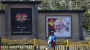 Warga setempat berjalan melewati foto Paus Fransiskus jelang kunjungannya ke Port Moresby, Papua Nugini, Rabu (4/9/2024). (AP Photo/Mark Baker)