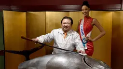 Miss Panama Darelys Santos (kanan) berpose saat berfoto bersama Presiden Sushi-Zanmai, Kiyoshi Kimura (tengah) dan seekor tuna sirip biru seberat 250 Kg di Tokyo, Jepang (12/11). (AFP Photo/Toshifumi Kitamura)