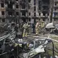 Petugas darurat memeriksa gedung apartemen bertingkat yang rusak akibat serangan rudal terbaru Rusia di Kryvyi Rih, Ukraina, Selasa (13/6/2023). (AP Photo/Andriy Dubchak)