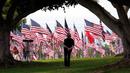 Seorang pengunjung melihat bendera Amerika Serikat (AS) untuk memperingati serangan teroris 11 September di halaman Universitas Pepperdine, Malibu, California, AS, Senin (11/9/2023). AS mengenang 22 tahun tragedi kelam serangan 11 September (9/11) di menara kembar World Trade Center (WTC), yang menewaskan nyaris 3.000 orang pada 2001. (AP Photo/Marcio Jose Sanchez)
