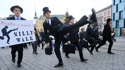 Seorang pria mengenakan kostum berjalan dengan mengangkat tinggi kakinya di Brno, Republik Ceko (7/1). Mereka mengenakan kostum tersebut untuk mengenang grup komedi asal Inggris, Monty Python. (AFP Photo/Radek Mica)