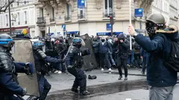 Pengunjuk rasa berhadapan dengan polisi anti huru hara saat unjuk rasa di ibukota Prancis, Paris, Kamis (31/3). Mereka menolak rancangan undang-undang sosialis pemerintah Prancis yang dinilai merugikan pekerja. (Thomas SAMSON/AFP)