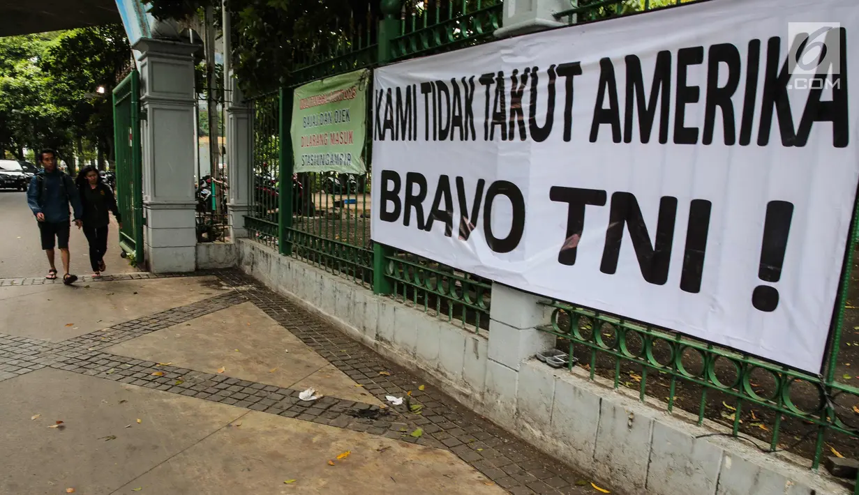 Sebuah spanduk bertulisan "Kami Tidak Takut Amerika Bravo TNI" terpampang di pagar Stasiun Gambir, Jakarta, Senin (23/10). Pemasangan spanduk ini diduga terkait undangan Panglima TNI yang ditolak masuk AS. (Liputan6.com/Faizal Fanani)