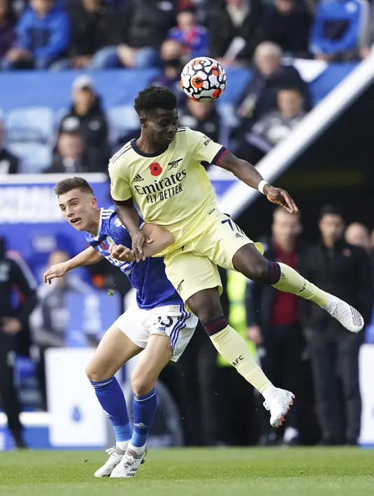Pemain Leicester City Luke Thomas (kiri) berebut bola dengan pemain Arsenal Bukayo Saka pada pertandingan Liga Inggris di Stadion King Power, Leicester, Inggris, 30 Oktober 2021. Arsenal menang 2-0. (Zac Goodwin/PA via AP)