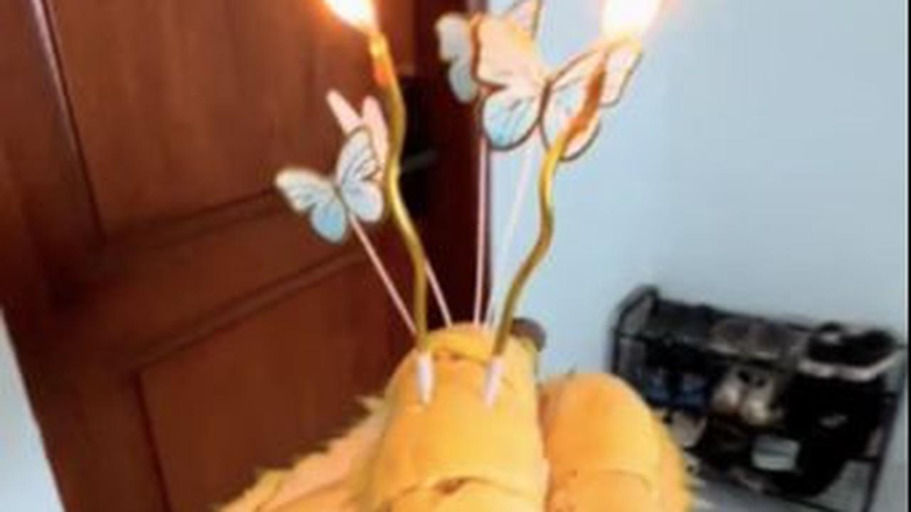 Menariknya, wanita ini bukan menggunakan kue tart, melainkan ia menggantinya dengan durian yang sudah dikupas setengah.