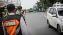 Petugas mengawasi kendaraan yang melintasi pos cekpoin penyekataan arus mudik di kawasan Pasar Jumat, Kamis (6/5/2021). Penyekatan dan cek poin dilakukan saat penerapan larangan mudik Lebaran 2021 sebagai upaya pencegahan penularan COVID-19. (Liputan6.com/Faizal Fanani)