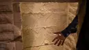 Arkeolog Ragab Dawood menunjukkan sebuah pahatan batu pada bagian dalam Step Pyramid atau Piramida Bertingkat di nekropolis Saqqara, Provinsi Giza, Mesir, Kamis (5/3/2020). Restorasi Piramida Bertingkat menelan biaya hampir USD  6,6 juta. (AP Photo/Maya Alleruzzo)