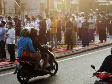 Sepeda motor melintas saat umat muslim melaksanakan salat Idul Adha 1442 H di Masjid Masjid Jami Al-Mubarok, Tangerang, Banten, Selasa (20/7/2021). Sebagian masjid melakukan pelaksanaan salat Idul Adha 1442 H, namun dengan protokol kesehatan yang ketat. (Liputan6.com/Angga Yuniar)