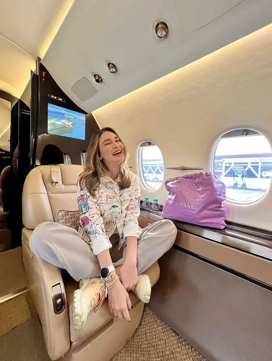 Seperti saat travelling ke Jogja, Luna Maya padukan jaket bermotif dengan celana khaki dan sneakers. Tas Chanel berwarna ungu jadi item yang mencolok [@lunamaya]