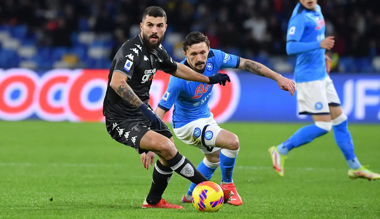Penyerang Empoli, Patrick Cutrone berebut bola dengan bek Napoli, Mario Rui dalam laga pekan ke-17 Serie A Liga Italia di Stadio Diego Armando Maradona, Senin (13/12/2021) dini hari WIB. Napoli secara mengejutkan tumbang di markas sendiri saat menjamu Empoli, 0-1. (Tiziana FABI / AFP)