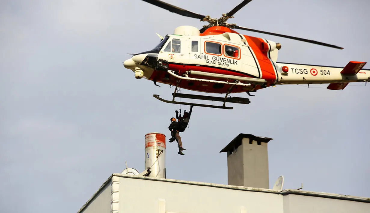Helikopter Penjaga Pantai menyelamatkan warga yang terdampar di atap gedung setelah banjir memaksa orang untuk mencari keselamatan di tempat yang tinggi dan tanah longsor, di kota Bozkurt provinsi Kastamonu, Kamis (12/8/2021). Musibah tersebut menewaskan lima orang. (IHA via AP)