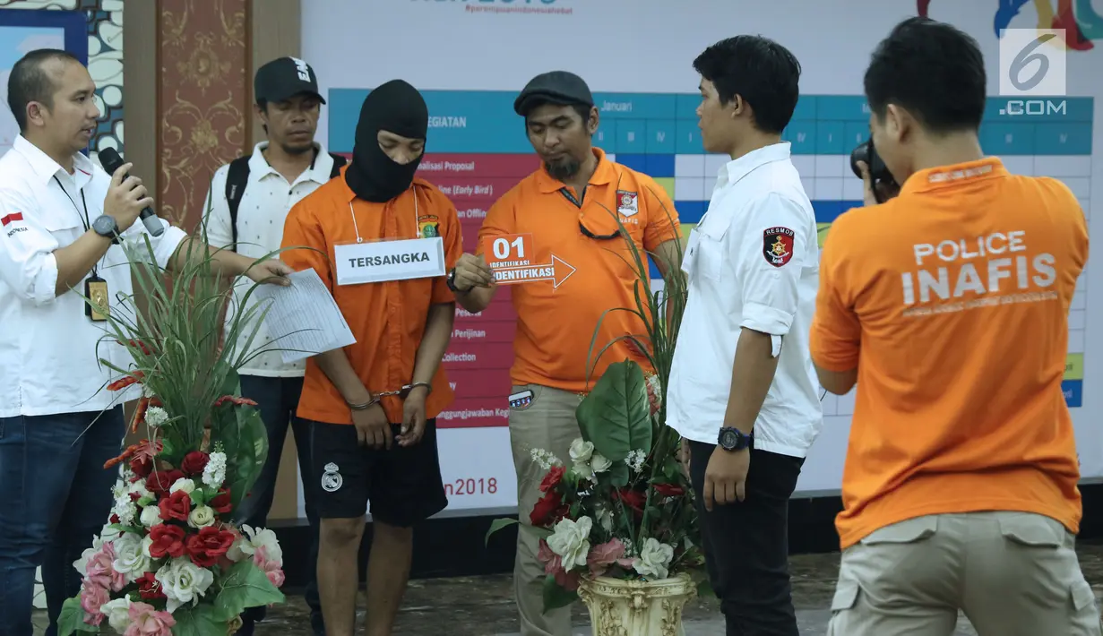 Tersangka HS pelaku kasus pembunuhan satu keluarga di Bekasi (ketiga kiri) melakukan pra-rekonstruksi di Polda Metro Jaya, Jakarta, Senin (19/11). 35 adegan diperagakan dari 57 yang akan diperagakan saat rekonstruksi. (Liputan6.com/Helmi Fithriansyah)