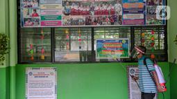 Seorang guru mendisinfeksi SDN Kenari 08, Jakarta, Selasa (6/4/2021). Skema yang akan diterapkan adalah pembelajaran tatap muka secara bergantian dengan maksimum 50 persen dari kapasitas ruangan. (Liputan6.com/Faizal Fanani)